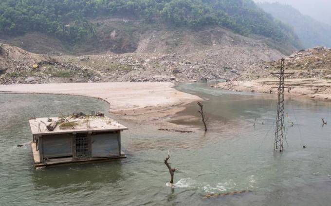 A house and an electric pole under the water due to the dam created by the Jure landslide in Bhotekoshi River in 2014 at Sindhupalchowk, Nepal (Photo by Nabin Baral)