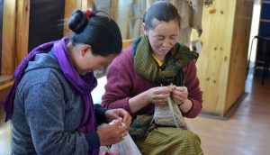 Two nomadic women knitting at a Pashmina shop in Leh owned by a cooperative of nomadic women of Changthang (Photo by Athar Parvaiz)
