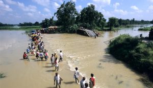 People moving to higher ground as a river in India overflowed its banks (Joerg Boethling / Alamy)
